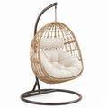 Sedia sospesa in rattan con cuscino in cotone crema e struttura in acciaio